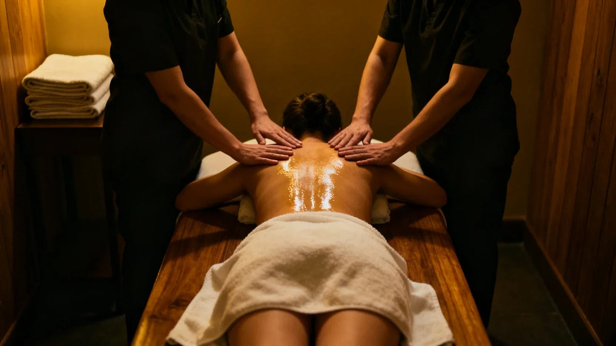Deux praticiens posent leurs quatre mains sur le dos huilé d'une femme allongée sur une table de massage