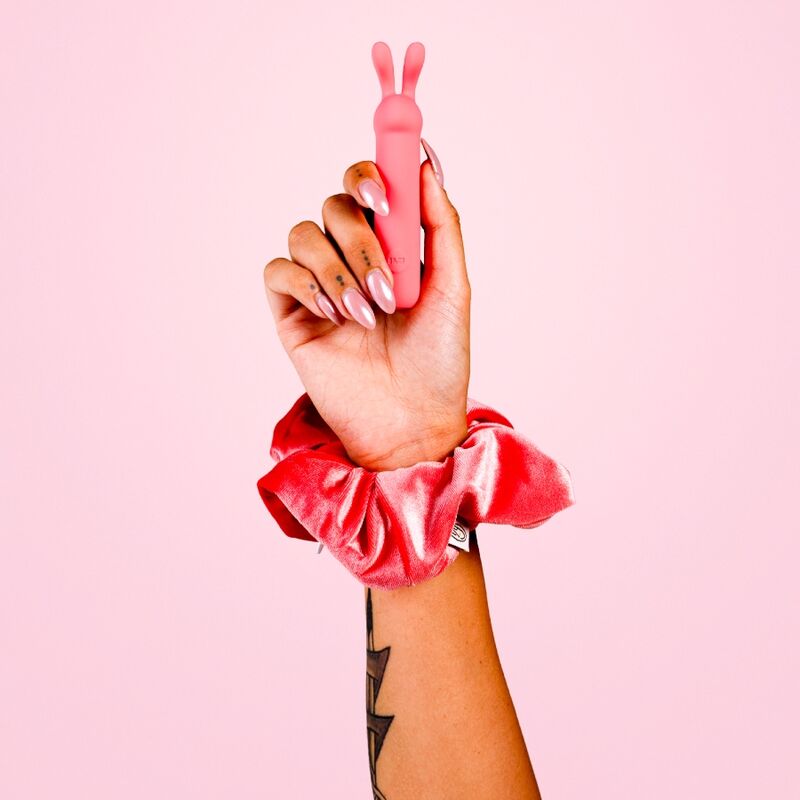 Poignet orné d'un chouchou tenant le bullet ILY Rabbit corail de Je Joue